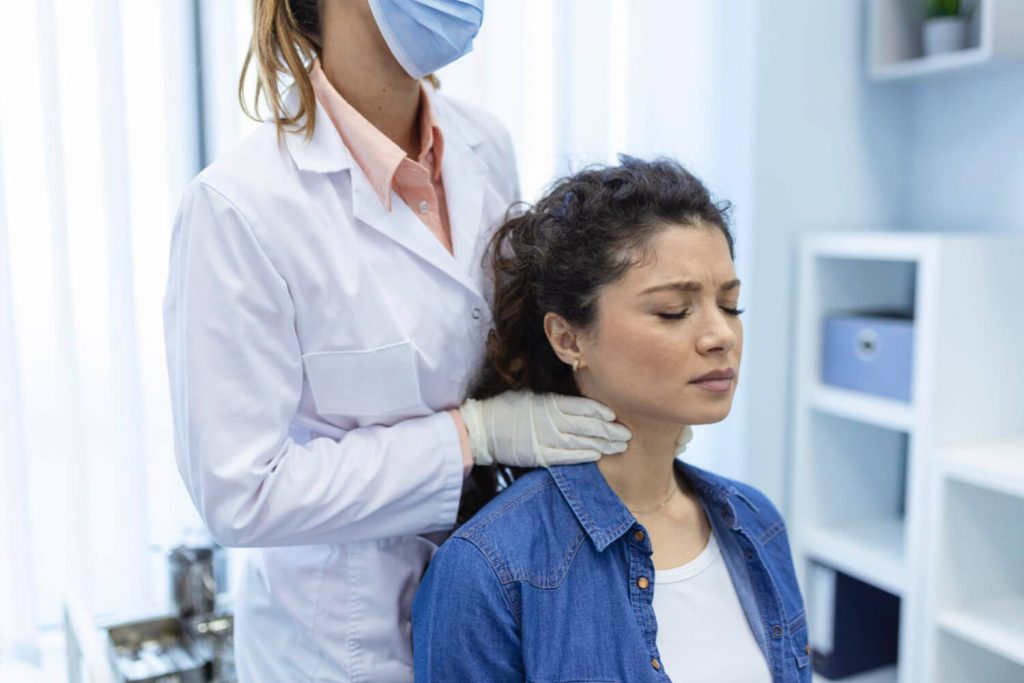 Médica endocrinologista examina uma mulher jovem em um consultório. 