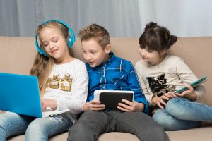 Crianças brincando com aparelhos de tecnologia