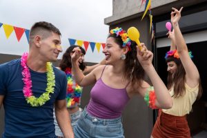 Três foliões se divertem no carnaval enquanto usam acessórios coloridos.