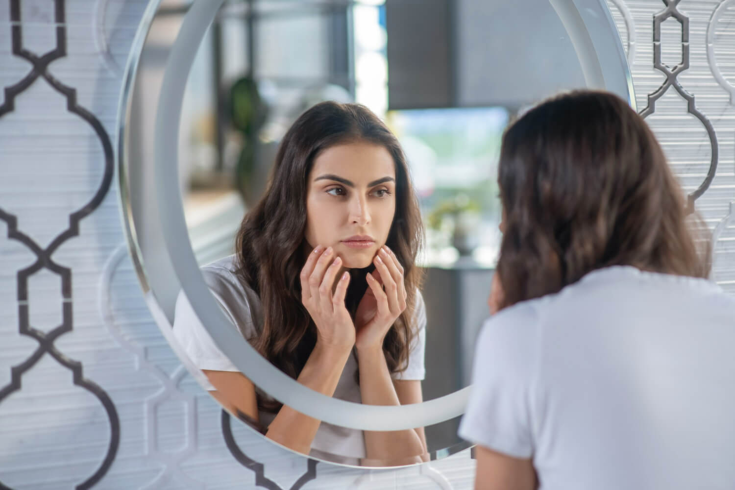 Mulher em frente ao espelho checando se apresenta sintomas do hisurtismo